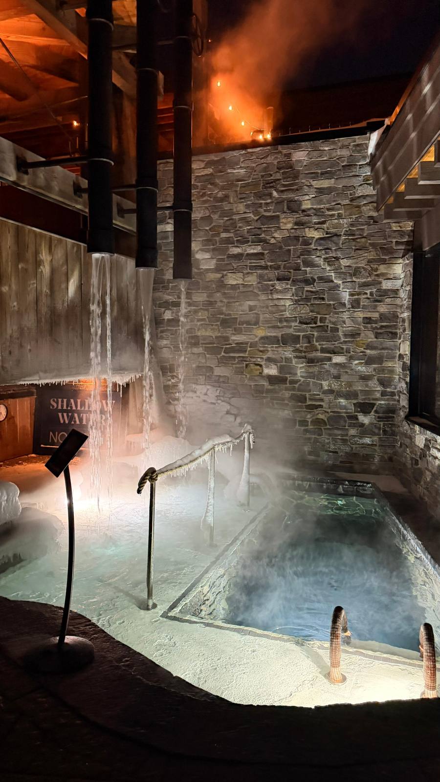 Thermea Spa Village – outdoor thermal pool in winter, steam rising from the water, stone walls